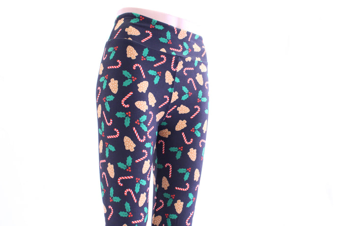 Show your holiday spirit with our candy cane and baked cookie black leggings by Jo Lina Boutique